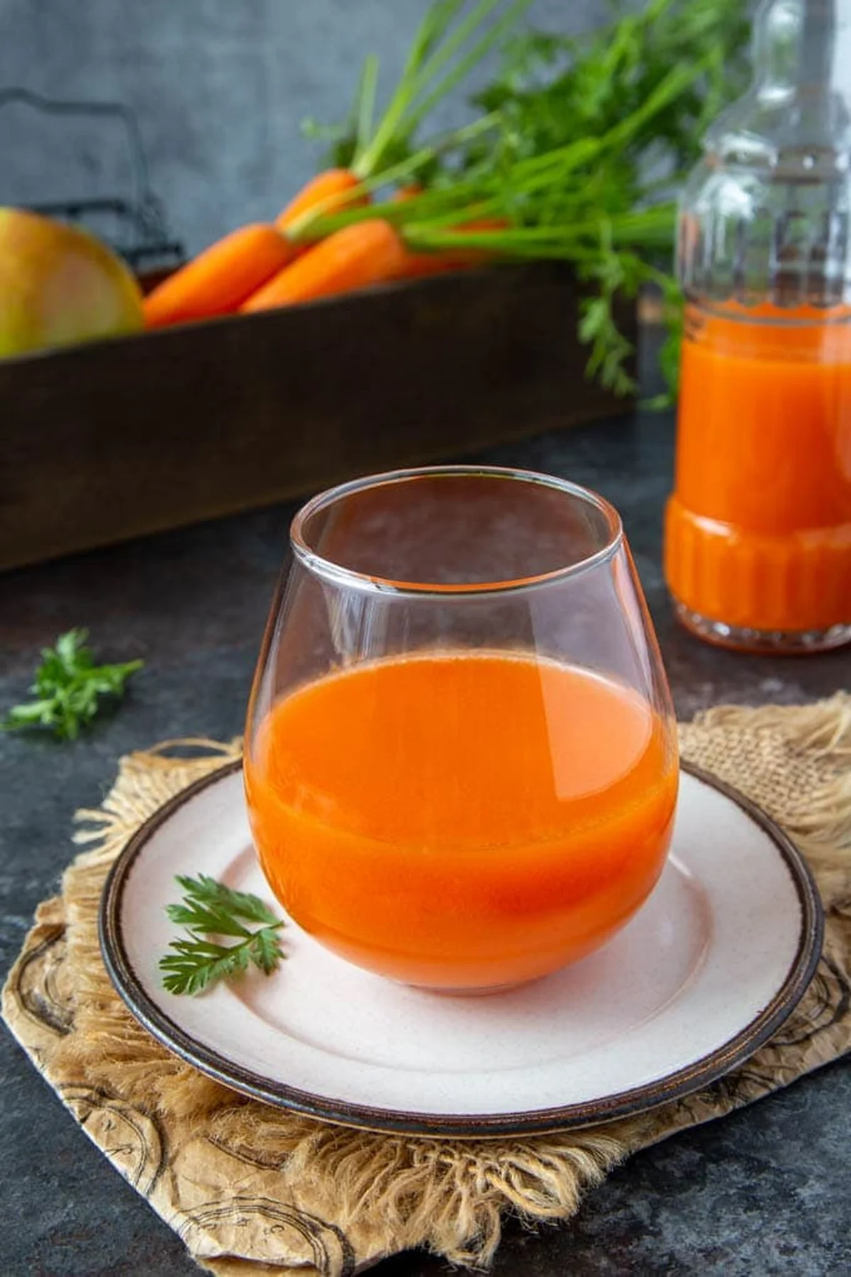 Glass of fresh carrot apple ginger juice on kitchen table