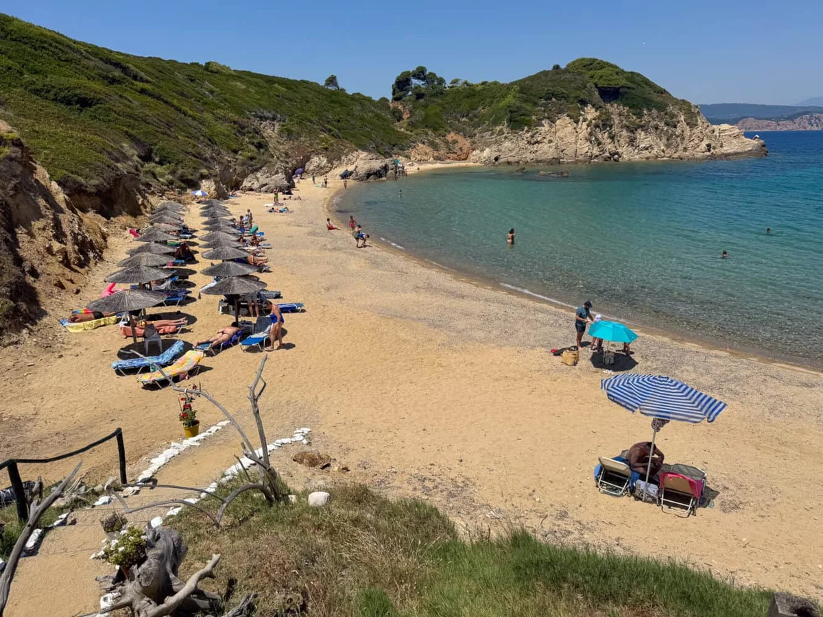 Krifi Ammos hidden beach beneath green cliffs
