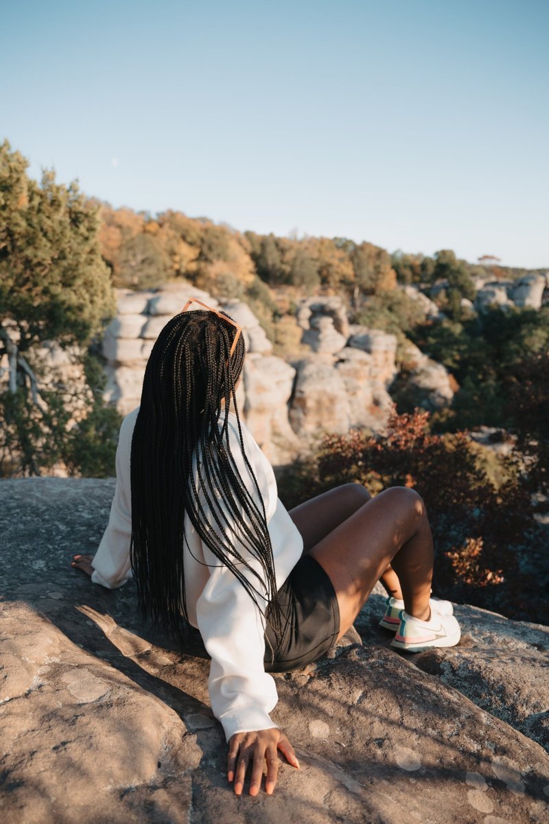 Woman from behind gazing over rock formations with crescent moon