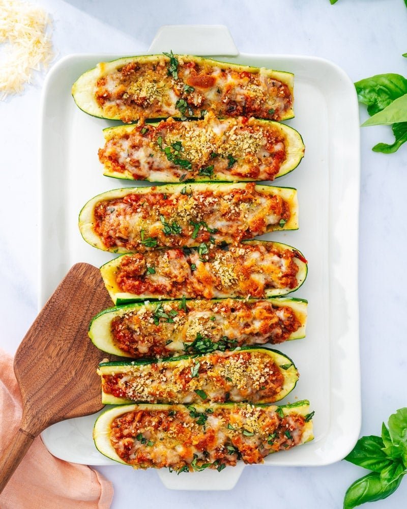 Baked zucchini boats with crispy topping and basil garnish