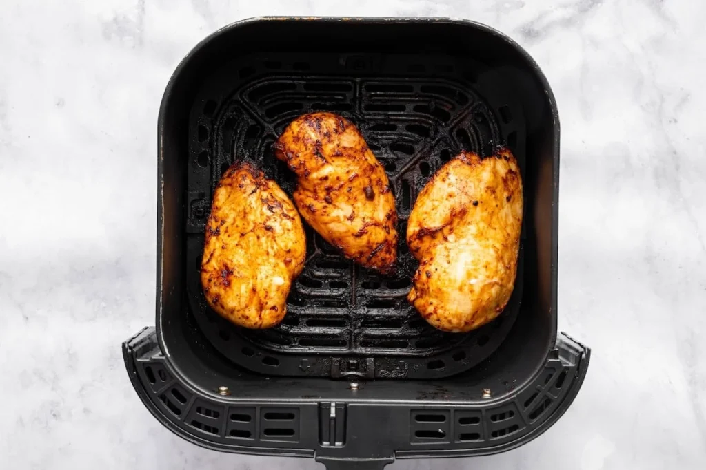 Cooked BBQ chicken pieces coated in glossy sauce