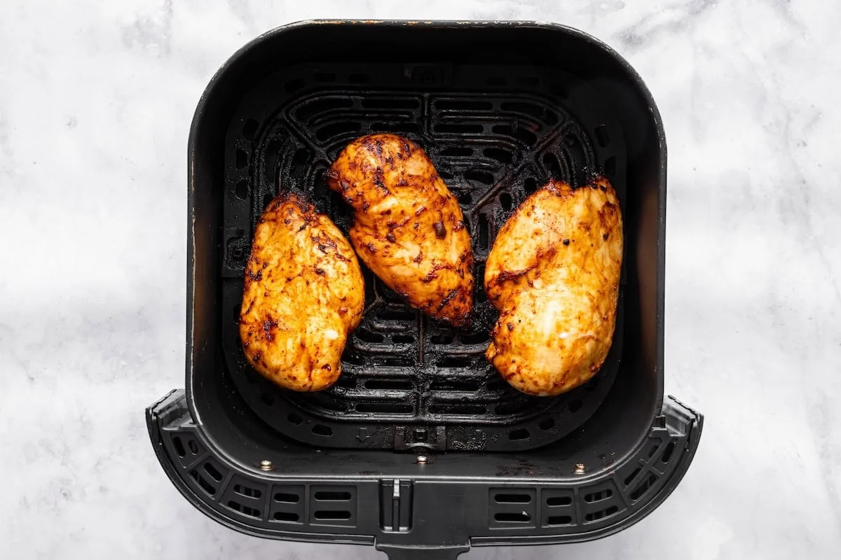 Cooked BBQ chicken pieces coated in glossy sauce