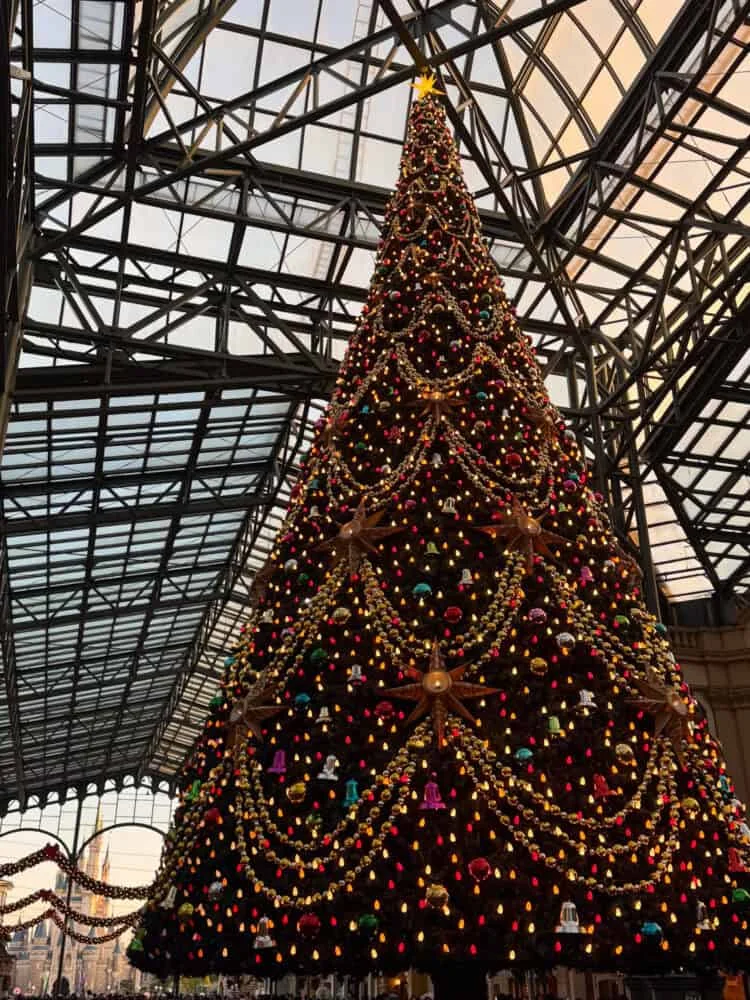 Huge decorated Christmas tree under a glass-roofed hall at Tokyo Disneyland