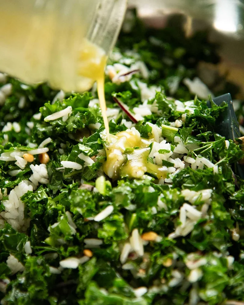 Apple cider vinegar dressing drizzled onto chopped kale leaves
