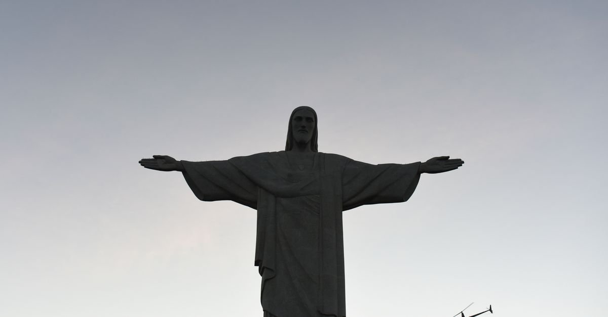 Christ the Redeemer statue with helicopter sky dusk