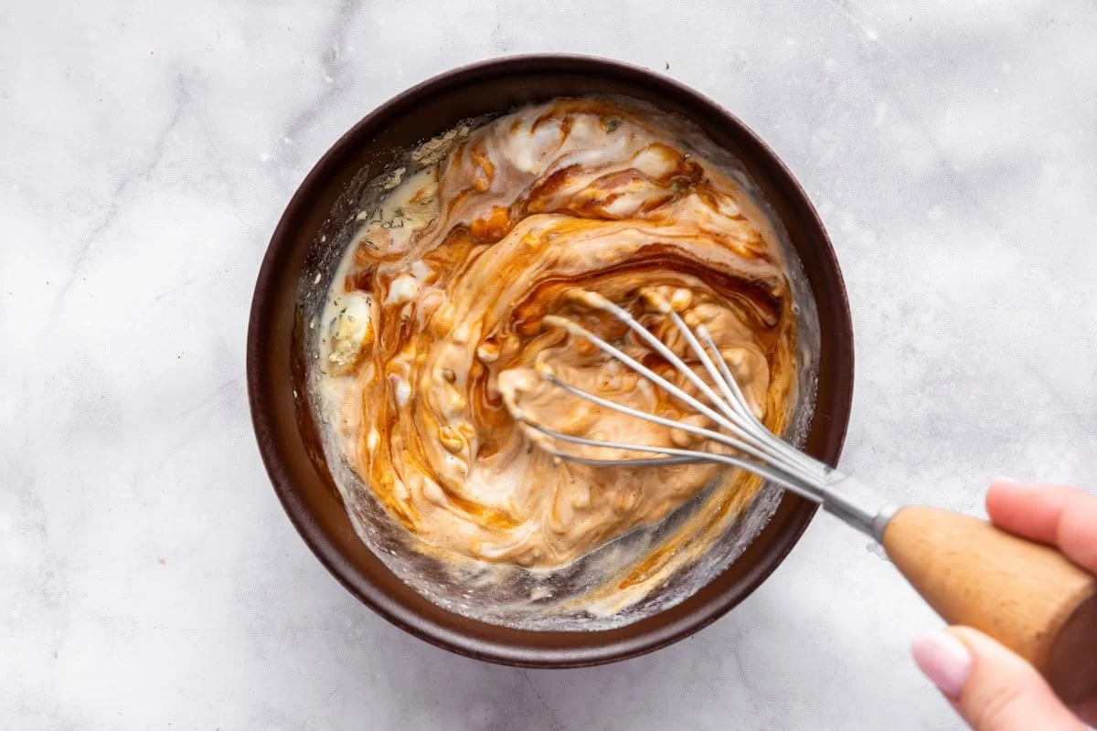 Whisked creamy high-protein BBQ ranch dressing in glass bowl