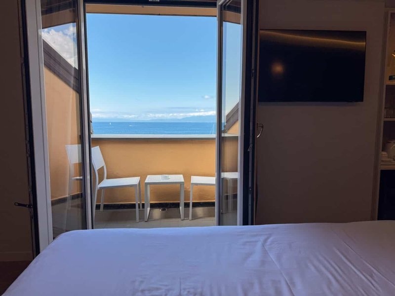 Sea view from bed through open balcony doors
