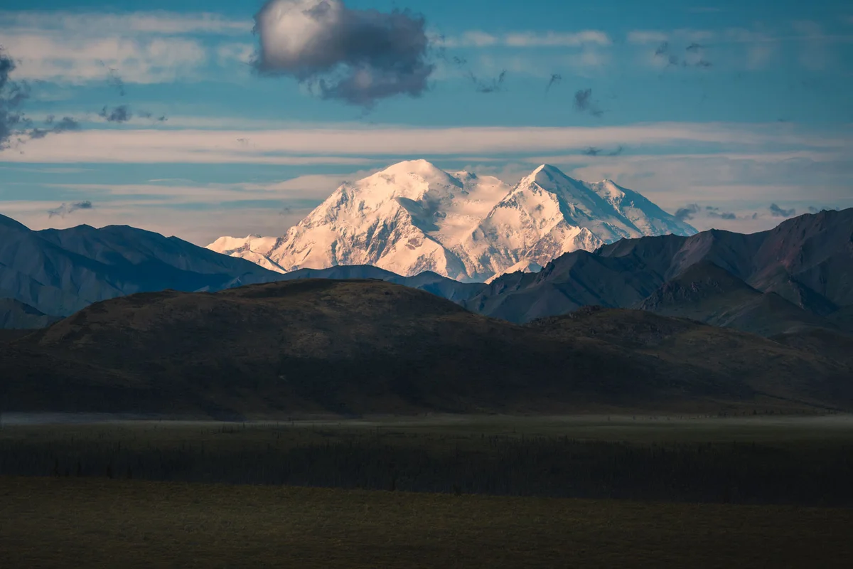 Denali mountain peak rising above clouds in Alaska