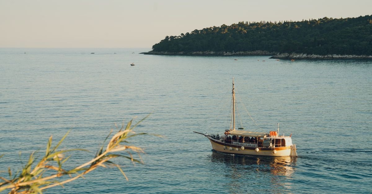 Small wooden boat near Dubrovnik coast with Adriatic blue water