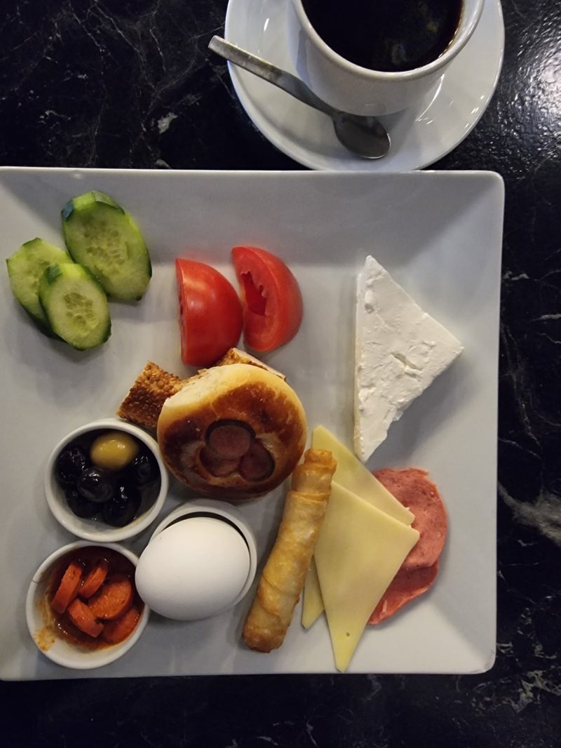 Plated breakfast spread with tomatoes, cheeses, and fruit bowls