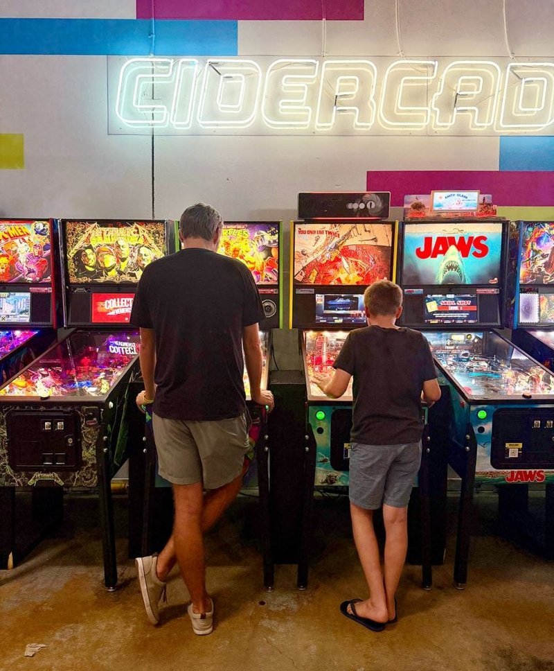 Family playing unlimited pinball at Cidercade in Dallas