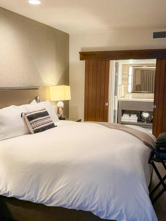 Calm hotel bedroom with warm bedside lighting